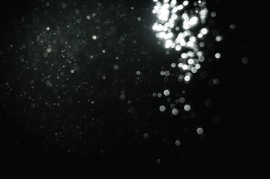 Siyah arkaplanlı kutlama için bulanık beyaz bokeh yıldızlarını kullan