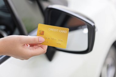 Closed up hand use credit card on car to pay for fuel