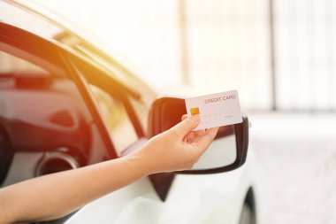 Closed up hand use credit card on car to pay for fuel