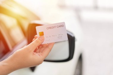 Closed up hand use credit card on car to pay for fuel