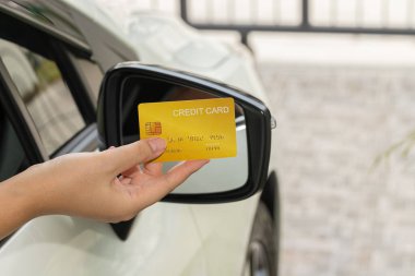 Closed up hand use credit card on car to pay for fuel