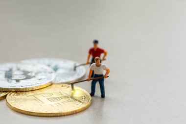 Gri zemin arkaplanı olan bitcoin grubu üzerinde çalışan makro madenci figürleri