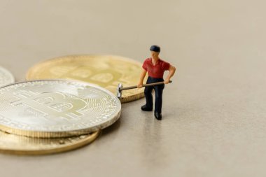 Gri zemin arkaplanı olan bitcoin grubu üzerinde çalışan makro madenci figürleri