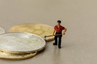 Gri zemin arkaplanı olan bitcoin grubu üzerinde çalışan makro madenci figürleri