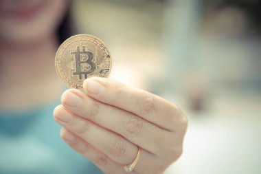 Elinde Bitcoin dijital para ve arka planı bulanık kripto para tutan güzel bir kadın. Kaşsız Toplum kavramı Web Sanal Para Madenciliği.