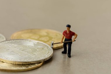 Gri zemin arkaplanı olan bitcoin grubu üzerinde çalışan makro madenci figürleri