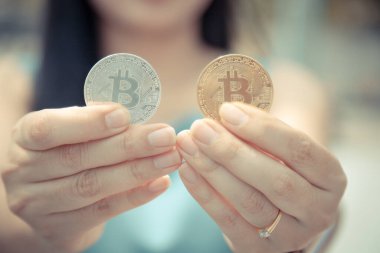 Elinde Bitcoin dijital para ve arka planı bulanık kripto para tutan güzel bir kadın. Kaşsız Toplum kavramı Web Sanal Para Madenciliği.