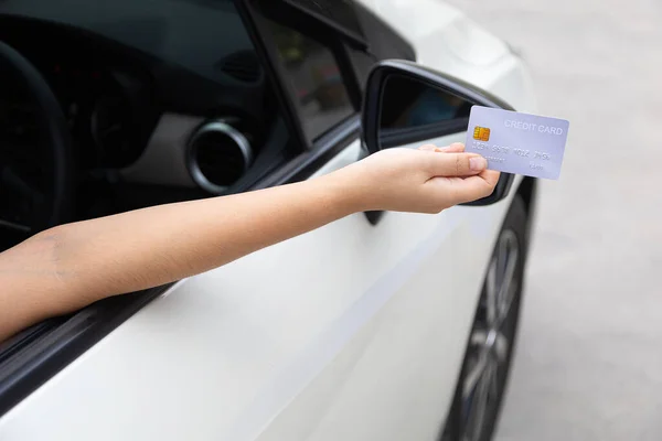 Closed up hand use credit card on car to pay for pay through the checkout checkpoint