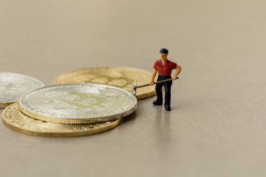 Gri zemin arkaplanı olan bitcoin grubu üzerinde çalışan makro madenci figürleri