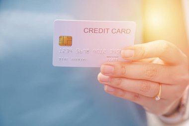 Finansal işlemler için kredi kartının kapalı el kayıtları ve bulanık arka plan kadınları