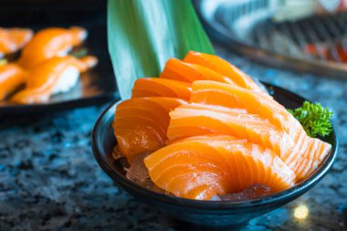 Salmon sashimi is often the first course in a formal Japanese meal over marble black background