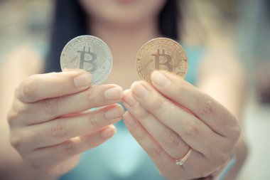Elinde Bitcoin dijital para ve arka planı bulanık kripto para tutan güzel bir kadın. Kaşsız Toplum kavramı Web Sanal Para Madenciliği.
