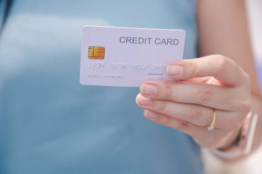 Finansal işlemler için kredi kartının kapalı el kayıtları ve bulanık arka plan kadınları