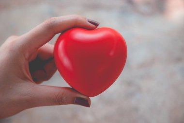 Kadın arka plan için kırmızı kalp kullanım tutun