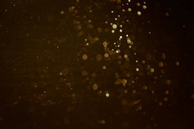 Siyah arkaplanlı, soyut altın bir su kaynağı.