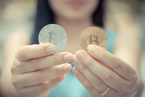 Elinde Bitcoin dijital para ve arka planı bulanık kripto para tutan güzel bir kadın. Kaşsız Toplum kavramı Web Sanal Para Madenciliği.