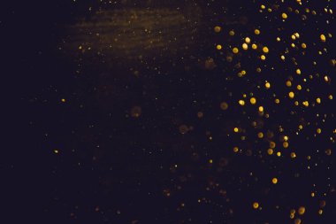 Siyah arkaplanda altın renkli ışıklar