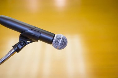 Oditoryumun altın arkaplanlı bir kürsüsündeki mikrofonu kapat.