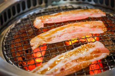 Kızarmış domuz eti ve kaliteli kömür dilimleri.