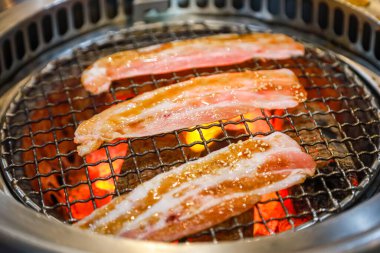 Kızarmış domuz eti ve kaliteli kömür dilimleri.