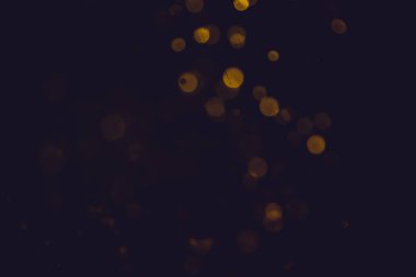 Özet olarak siyah arkaplanı olan güzel altın bokeh.