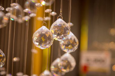 Güzel kristal avizeler fırçalanmış cam kristaller arasından yansıyan sıcak ışık Bokeh arka planlı klasik avizeye asılı.