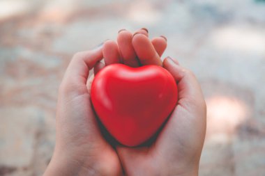 Kadın arka plan için kırmızı kalp kullanım tutun