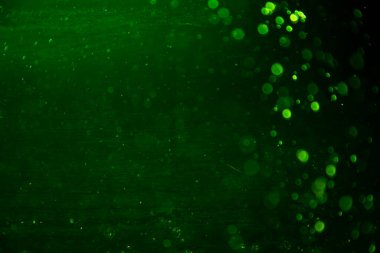 Siyah arkaplanı olan neon ışıkları tarafından oluşturulan klasik yeşil bokeh