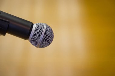 Oditoryumun altın arkaplanlı bir kürsüsündeki mikrofonu kapat.