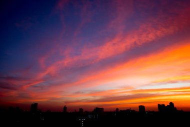 Gölge arkaplanda şehir olan gün batımının bulanık görüntüsü