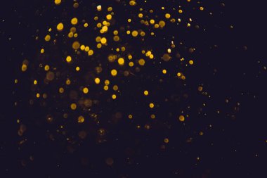 Siyah arkaplanı olan neon ışıkları tarafından oluşturulan klasik altın bokeh