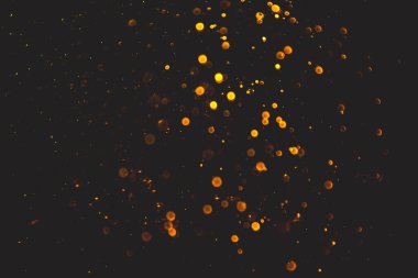 Siyah arkaplanı olan neon ışıkları tarafından oluşturulan klasik altın bokeh