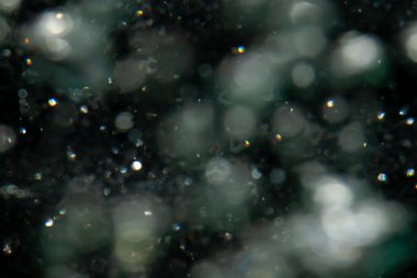 Siyah arkaplanda sudan gelen ışık bokeh