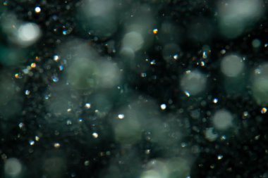 Siyah arkaplanda sudan gelen ışık bokeh