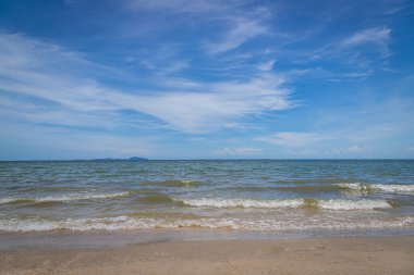 Kumsalda kumlar, deniz ve mavi gökyüzü arka planı.