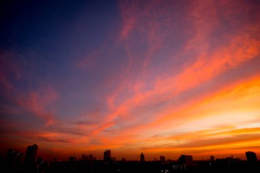 Gölge arkaplanda şehir olan gün batımının bulanık görüntüsü