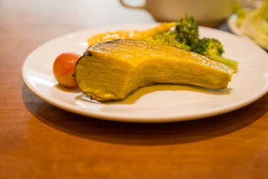 Servis masasında seramik tabakta sebze salatası karışımı.