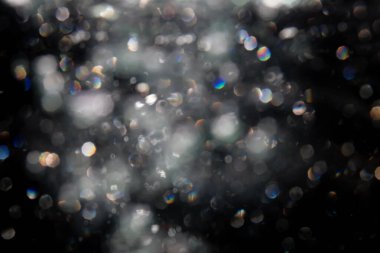 Siyah arkaplanda sudan gelen ışık bokeh