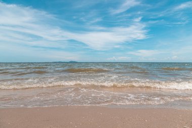 Kumsalda kumlar, deniz ve mavi gökyüzü arka planı.