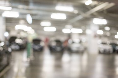 Binanın altındaki otoparkta park halindeki birçok arabanın görüntüsü bulanık. Alışveriş merkezine alışverişe gitmek için. Güvenli, parlak bir park yeri var..
