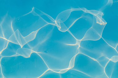 Güneşi yansıtan mavi havuz suyu