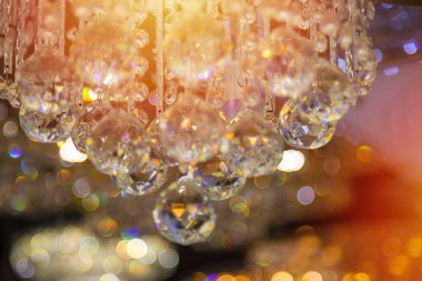 Güzel kristal avizeler. Sıcak ışık. Fırçalanmış cam kristallerin arasından yansıyan ışık.