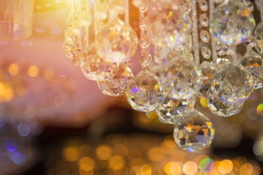 Güzel kristal avizeler. Sıcak ışık. Fırçalanmış cam kristallerin arasından yansıyan ışık.