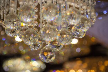 Güzel kristal avizeler. Sıcak ışık. Fırçalanmış cam kristallerin arasından yansıyan ışık.