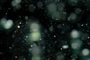 Siyah arkaplanda sudan gelen ışık bokeh