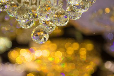 Güzel kristal avizeler. Sıcak ışık. Fırçalanmış cam kristallerin arasından yansıyan ışık.