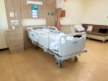 Lüks ve modern bir hasta odasındaki hastane yatağının bulanık görüntüsü. Atmosfer temiz ve etrafındaki manzarayı görebilirsiniz. Odanın etrafında pencereler var..