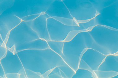 Güneşi yansıtan mavi havuz suyu