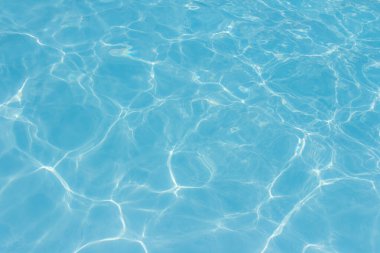 Işık yüzme havuzundaki suda maviyi yansıtıyor. Taze ve canlı görünüyor. Duvar kağıdı arka planı olarak kullanılabilir.