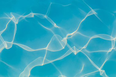 Güneşi yansıtan mavi havuz suyu